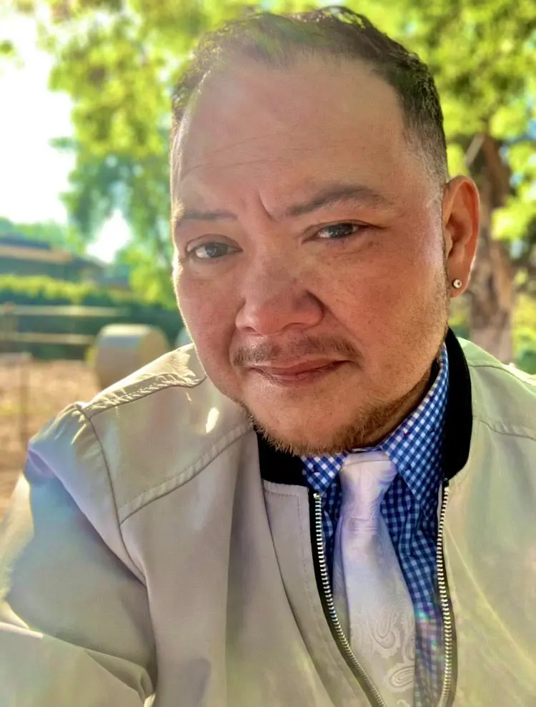 Headshot of man in light jacket and tie.