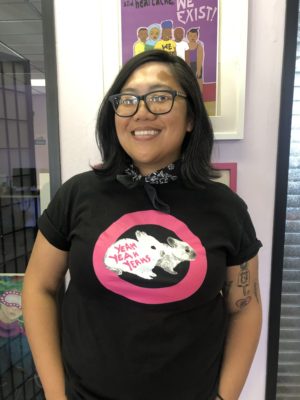 A woman wearing glasses and a black shirt with a pink bow