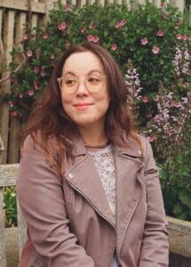 A woman in glasses and a leather jacket.