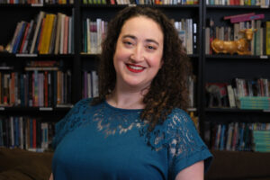 Person with long, curly hair and dark blue top