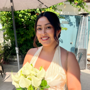 Smiling bride holding calla lily bouquet.